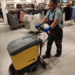 Співробітник клінінгової компанії Юнона миє підлогу професійною підлогомийною машиною Karcher у магазині одягу.